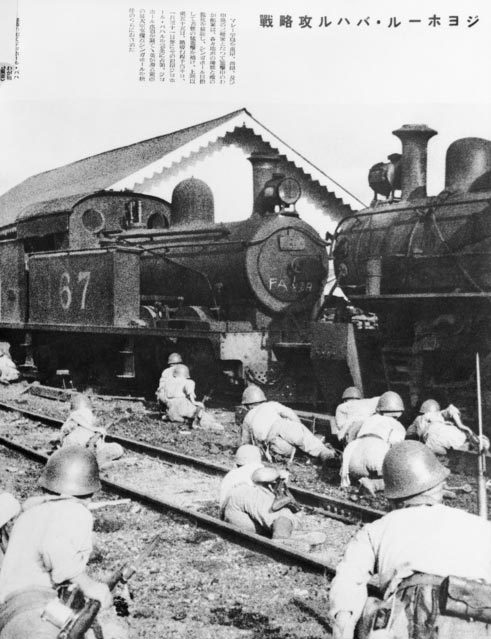 <p>Japanese troops take cover behind steam engines in Johore, Malaya</p>
