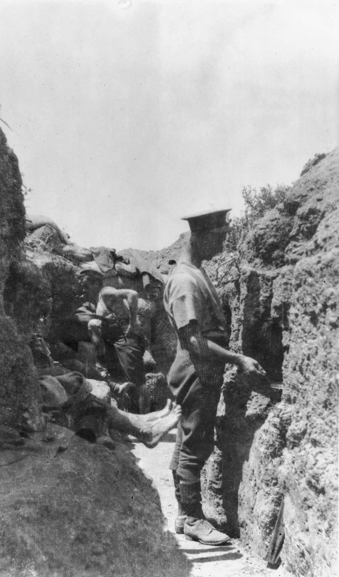<p>A soldier stirs a cooking pot in a hole in the wall of a trench, Gallipoli, 1915</p>
