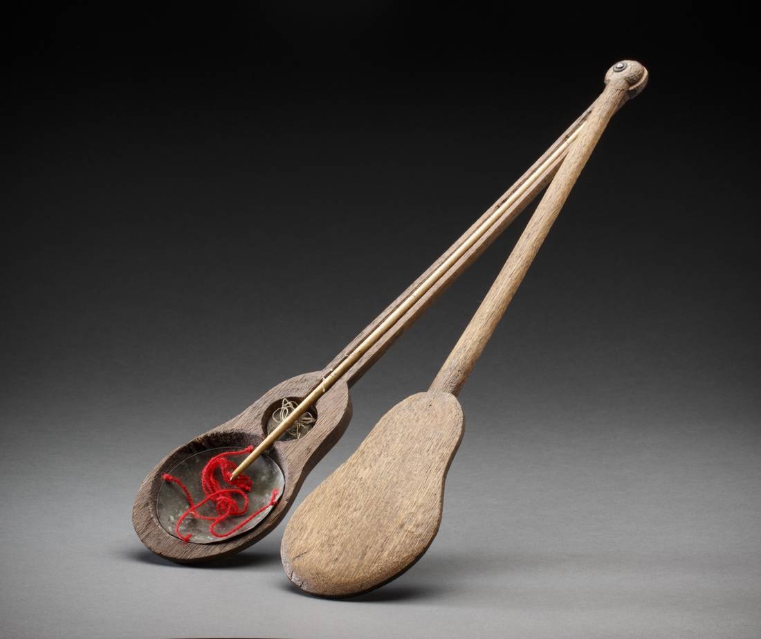A set of brown coloured wooden banjo shaped Chinese scales.