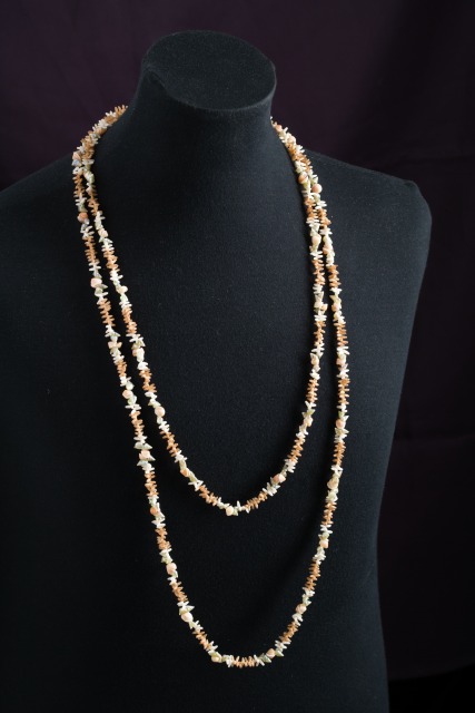 Shell necklace on a black torso mannequin.  