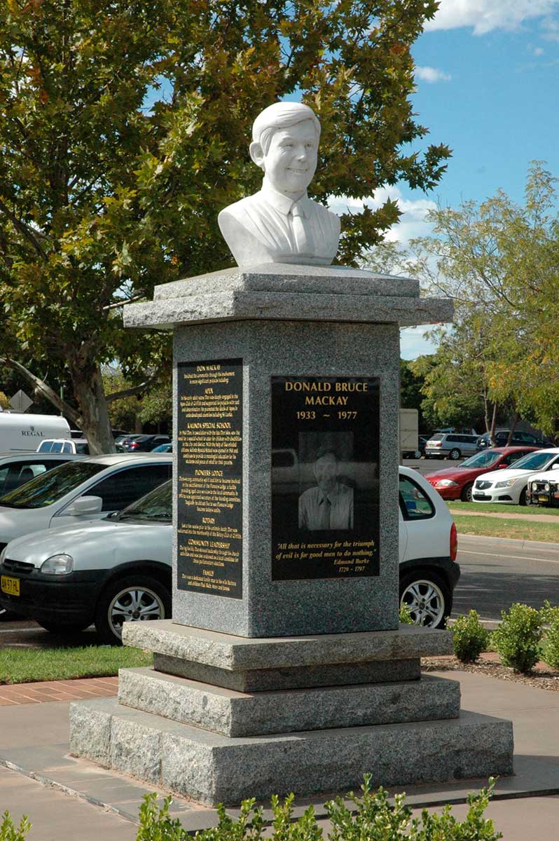 Memorial headstone featuring the bust of Donald Bruce Mackay. Plaques fixed to the stele below displays his photograph and related text.