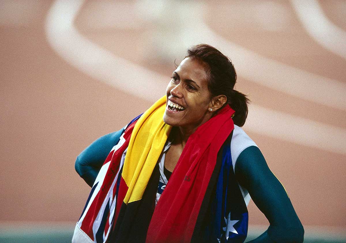 <p>Cathy Freeman after winning the 400m final at the Sydney Olympics, with the Australian and Aboriginal flags around her shoulders, 25 September 2000</p>
