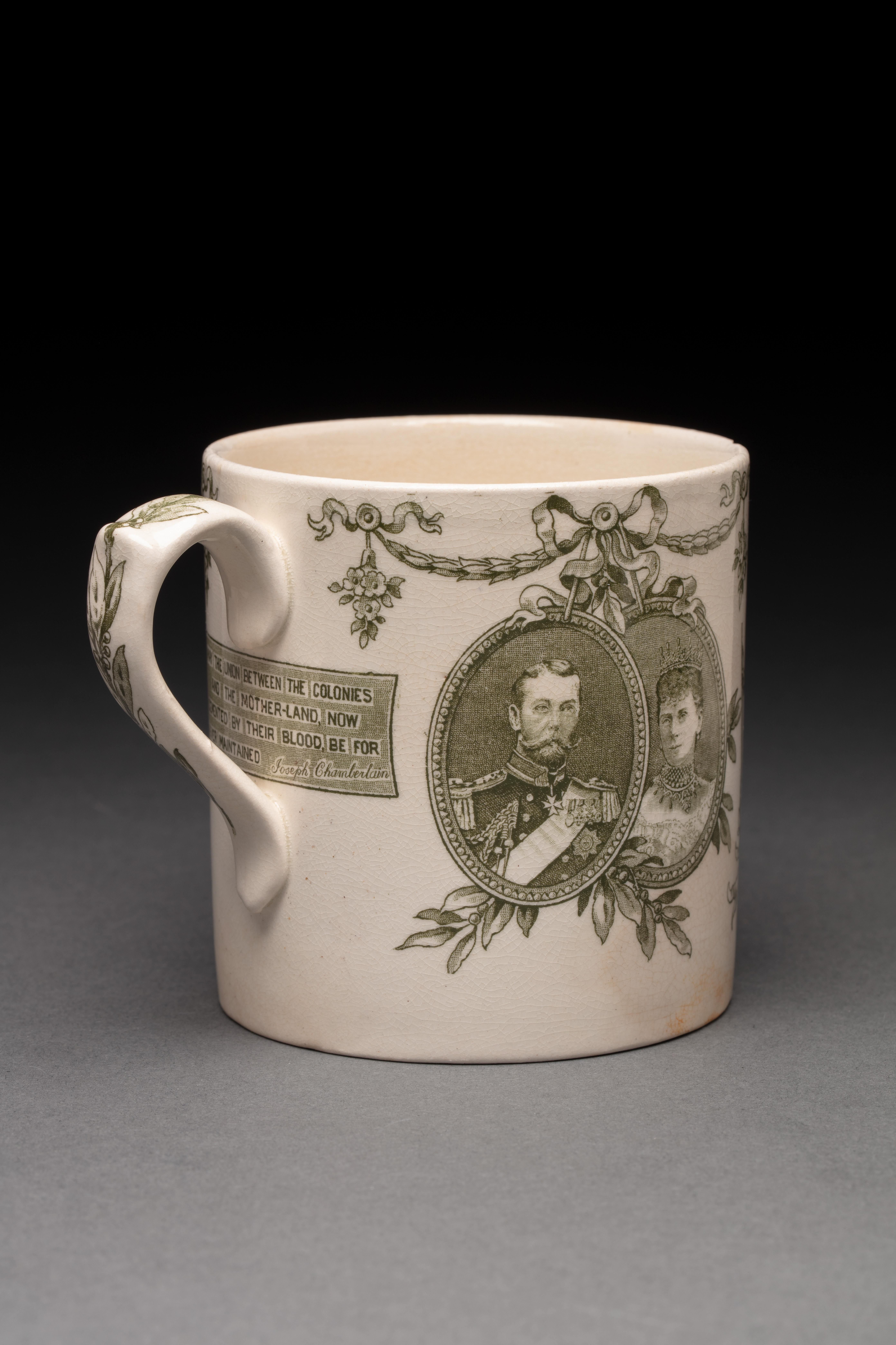  A cream earthenware mug featuring a green transfer print of Queen Victoria centred inside a wreath border on the front flanked by a British and an Australian soldier and 'AUSTRALIAN FEDERATION 1901' inscribed within a ribbon banner amongst flowers at the bottom.