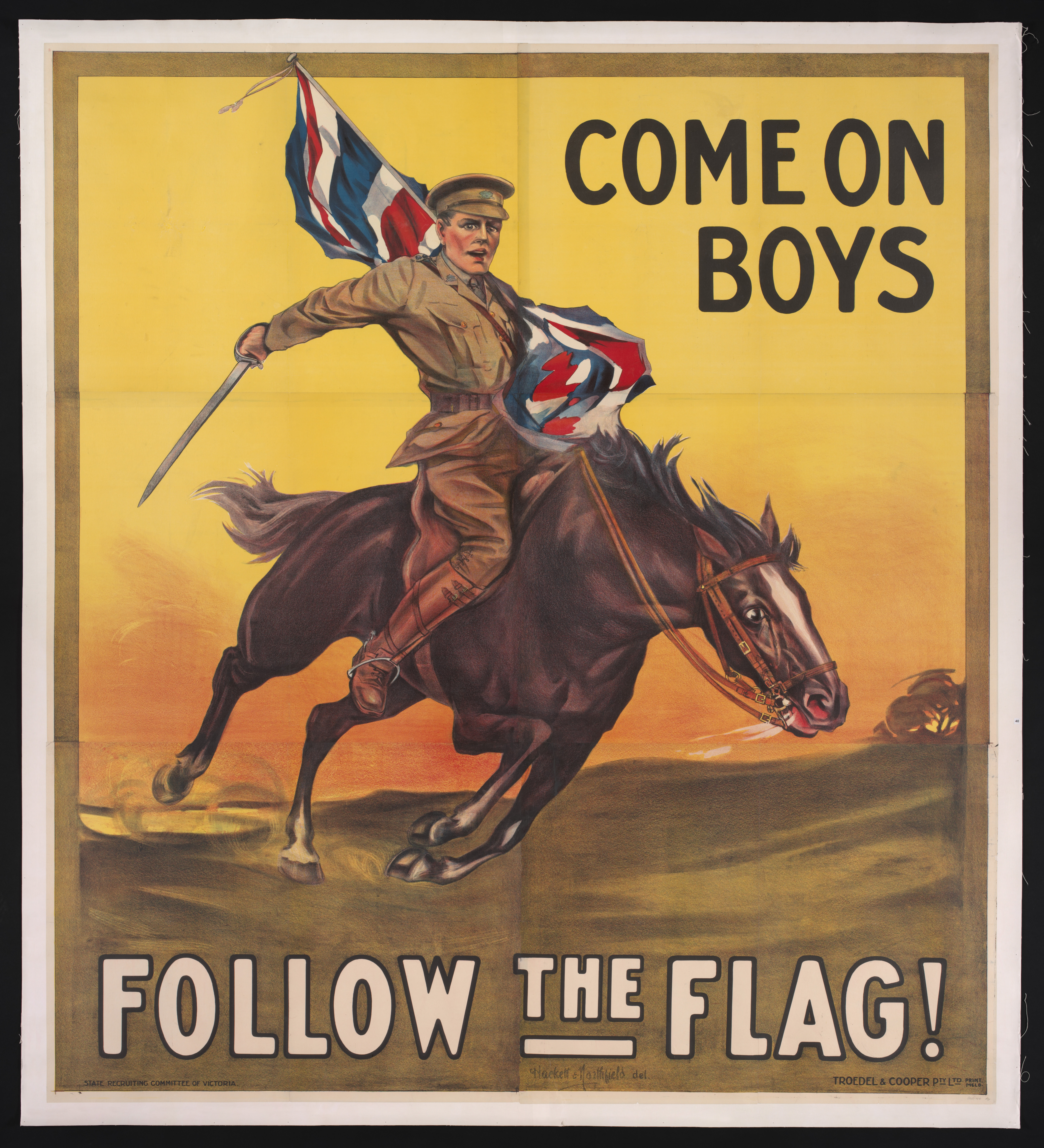  A billboard-sized recruitment poster of a soldier riding a brown horse while holding a sword and a British flag. The horse and soldier are galloping across a green field backed by a yellow sky. The man is wearing a khaki coloured uniform and a peaked cap. Black text in the top right corner reads ‘COME ON BOYS’, while below the horse the words 'FOLLOW THE FLAG!' stretch across the poster. 