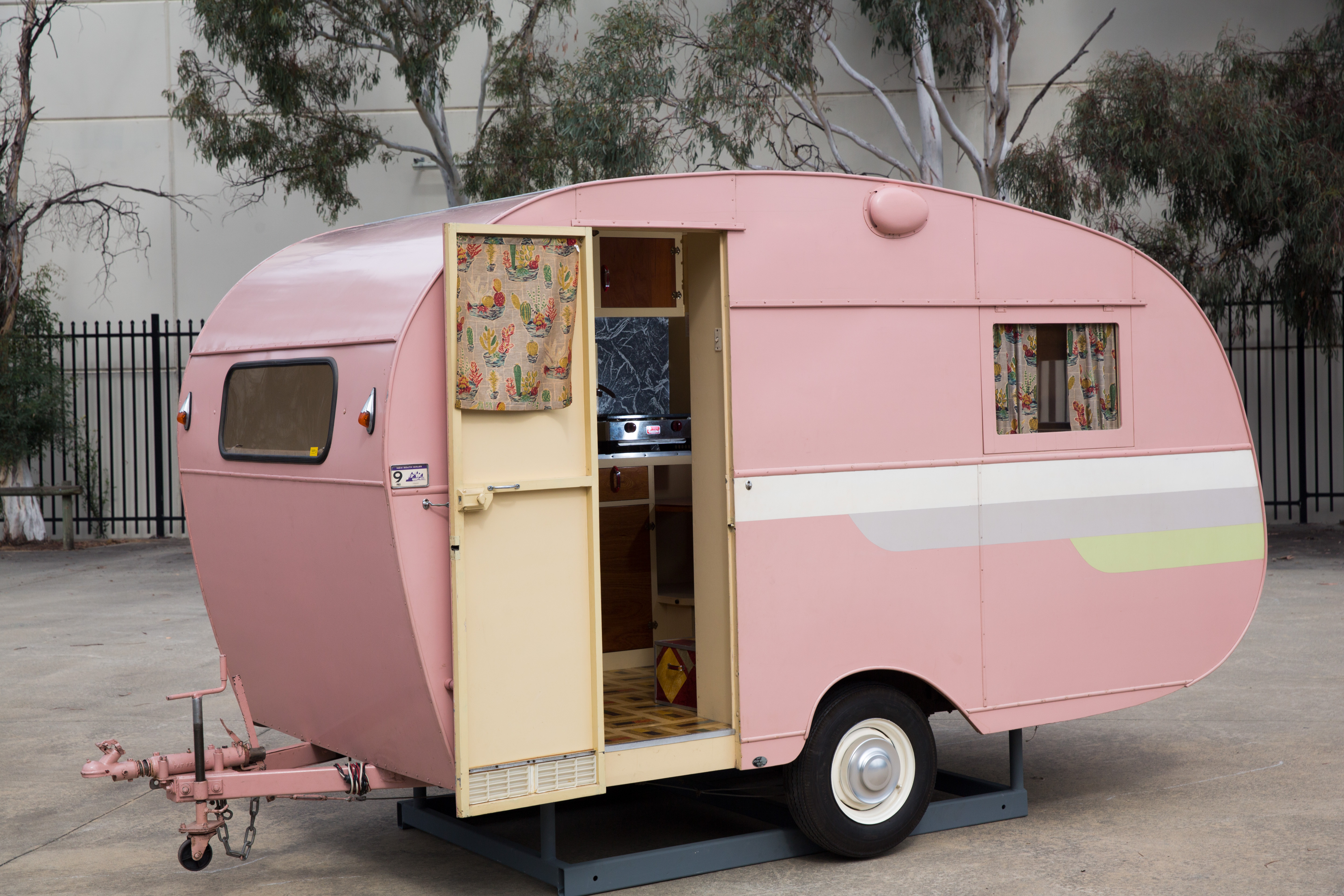 ropert 'Trailaway' three-berth touring caravan. The body of the caravan has a wooden frame clad in screwed-on pink-painted aluminium sheets and half-round wooden edging, which covers the joins between them. 