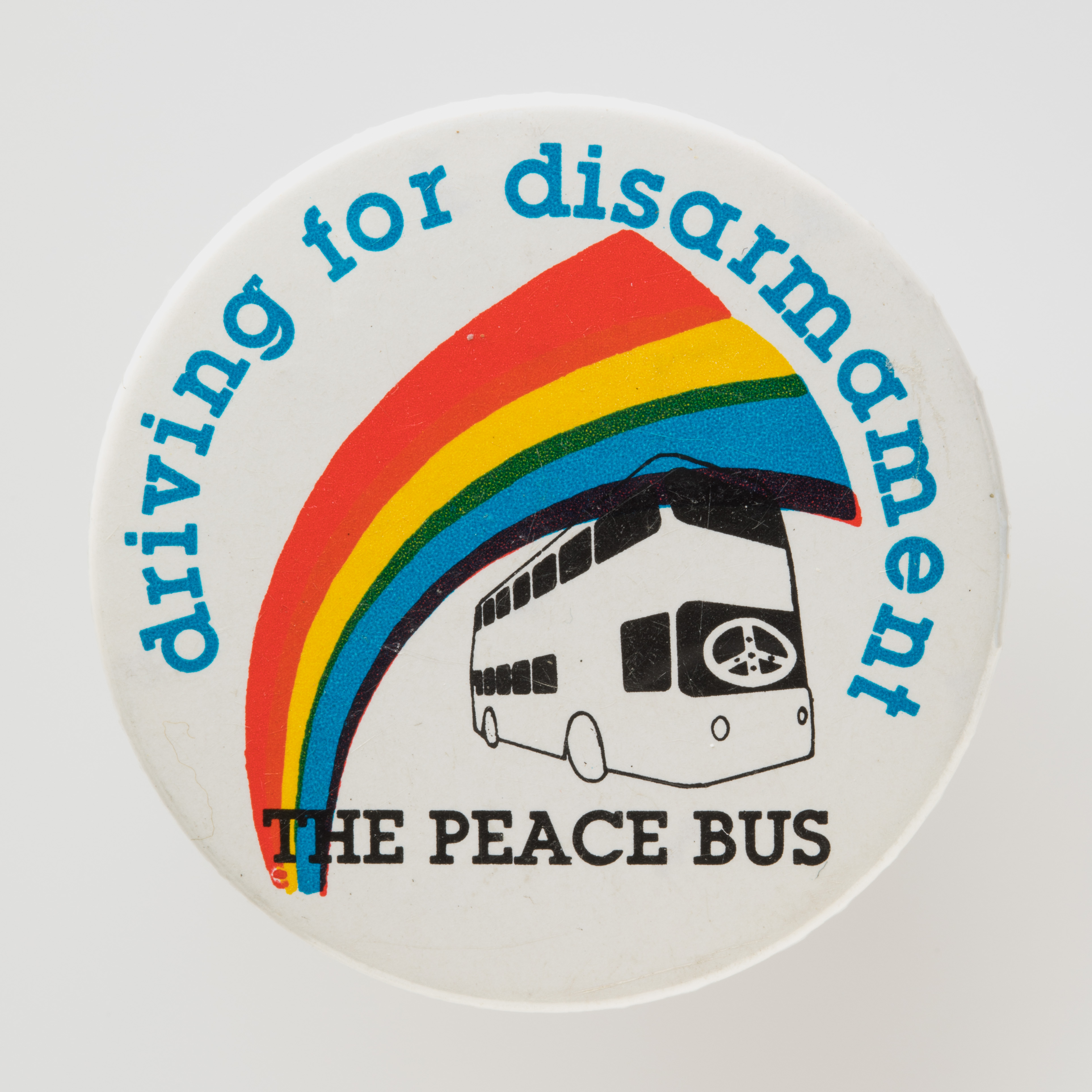  Badge featuring a sketch of a Leyland Atlantean double-decker bus with a rainbow over the top, labelled 'THE PEACE BUS / driving for disarmament'.