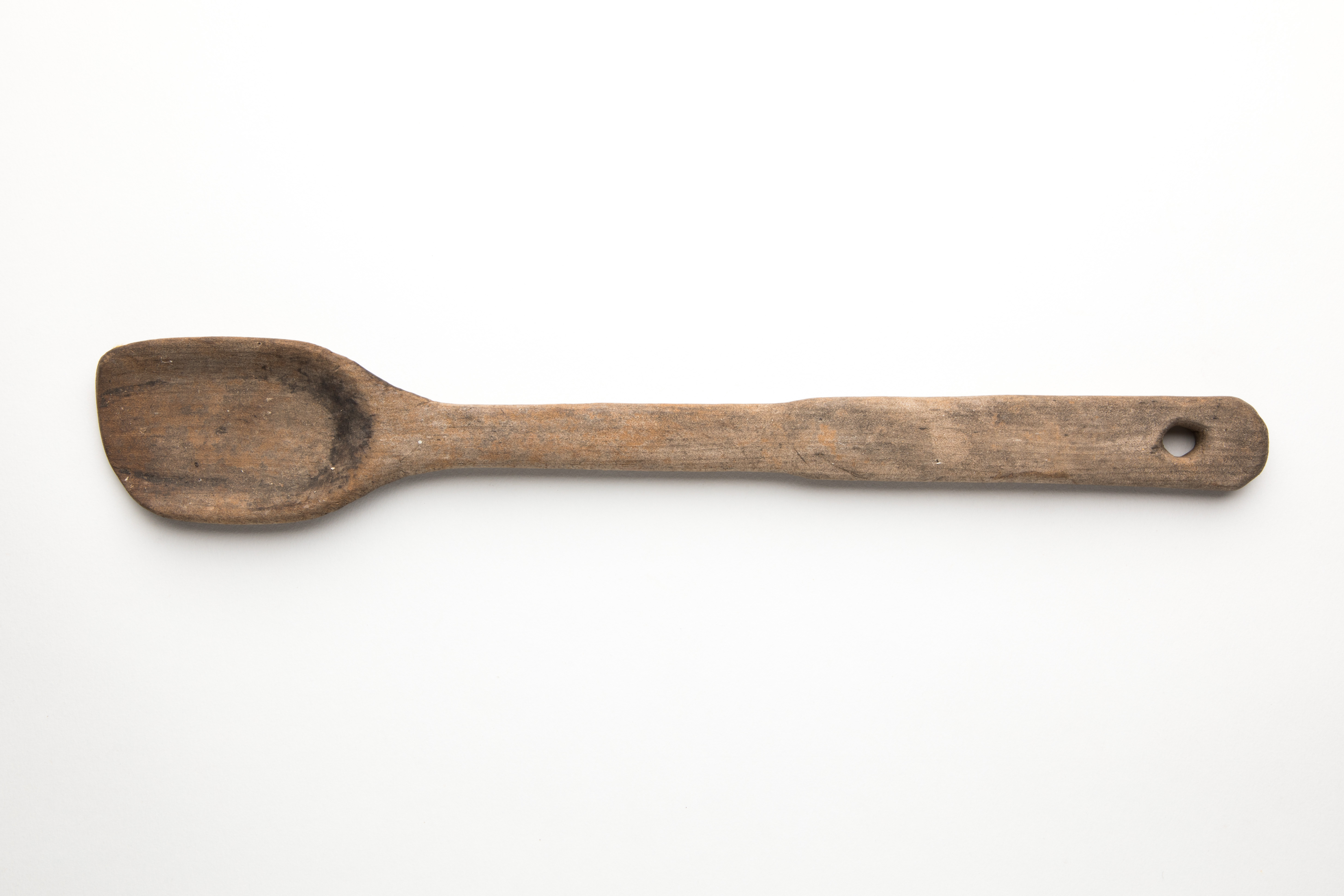  Hand-carved wooden spoon with a hole in the handle for hanging