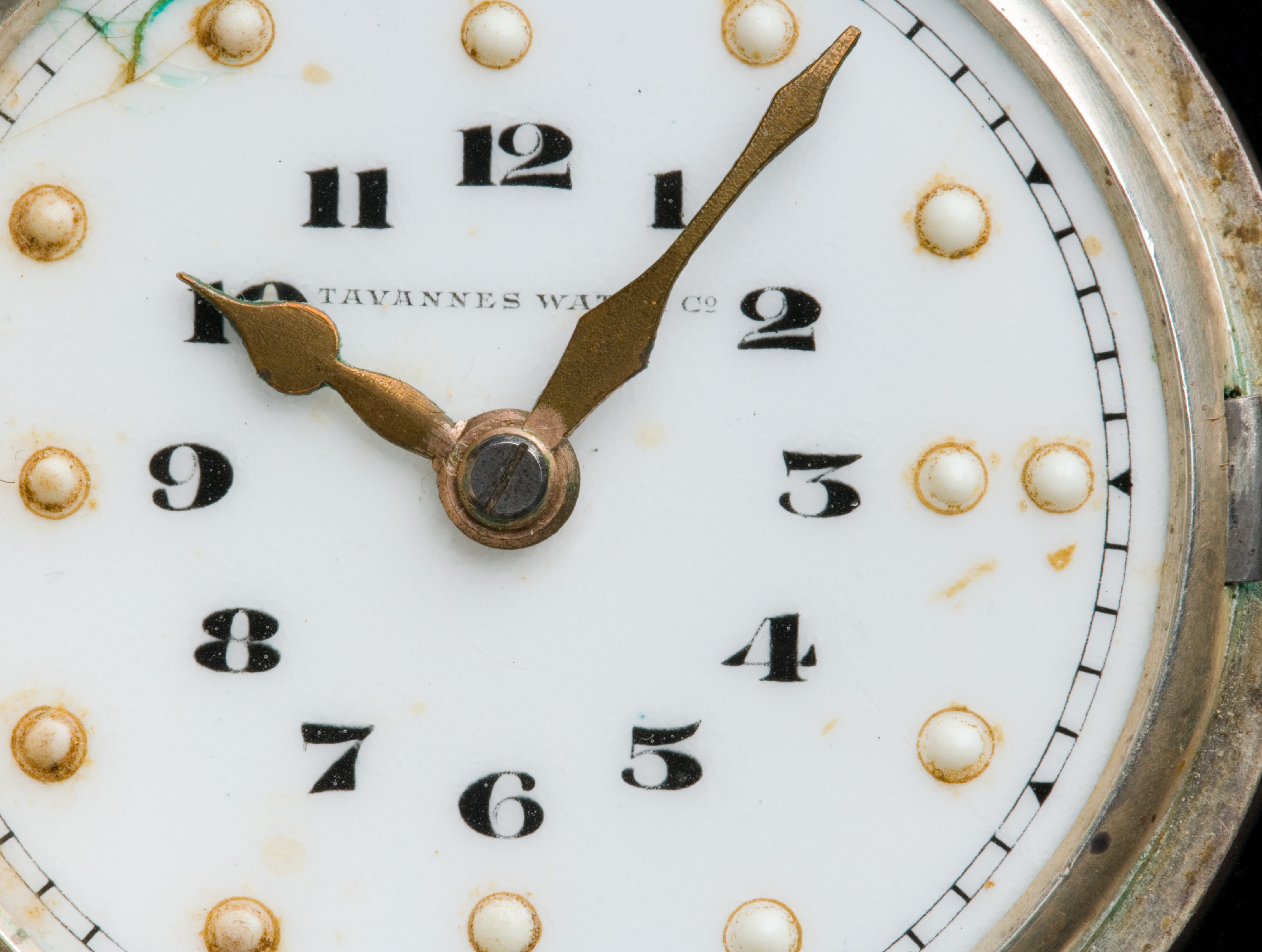  A braille pocket watch which has a black and white enamelled dial with 'TAVANNES WATCH C2' and 'SWISS MADE' lettering, a metal case with a spring-hinged circular lid which is hinged from the left side, and an attached fob chain. The dial has an inner circle of black numbers, a middle circle of raised bumps with two bumps indicating the 12, 3, 6 and 9 positions and single bumps for the remaining. 