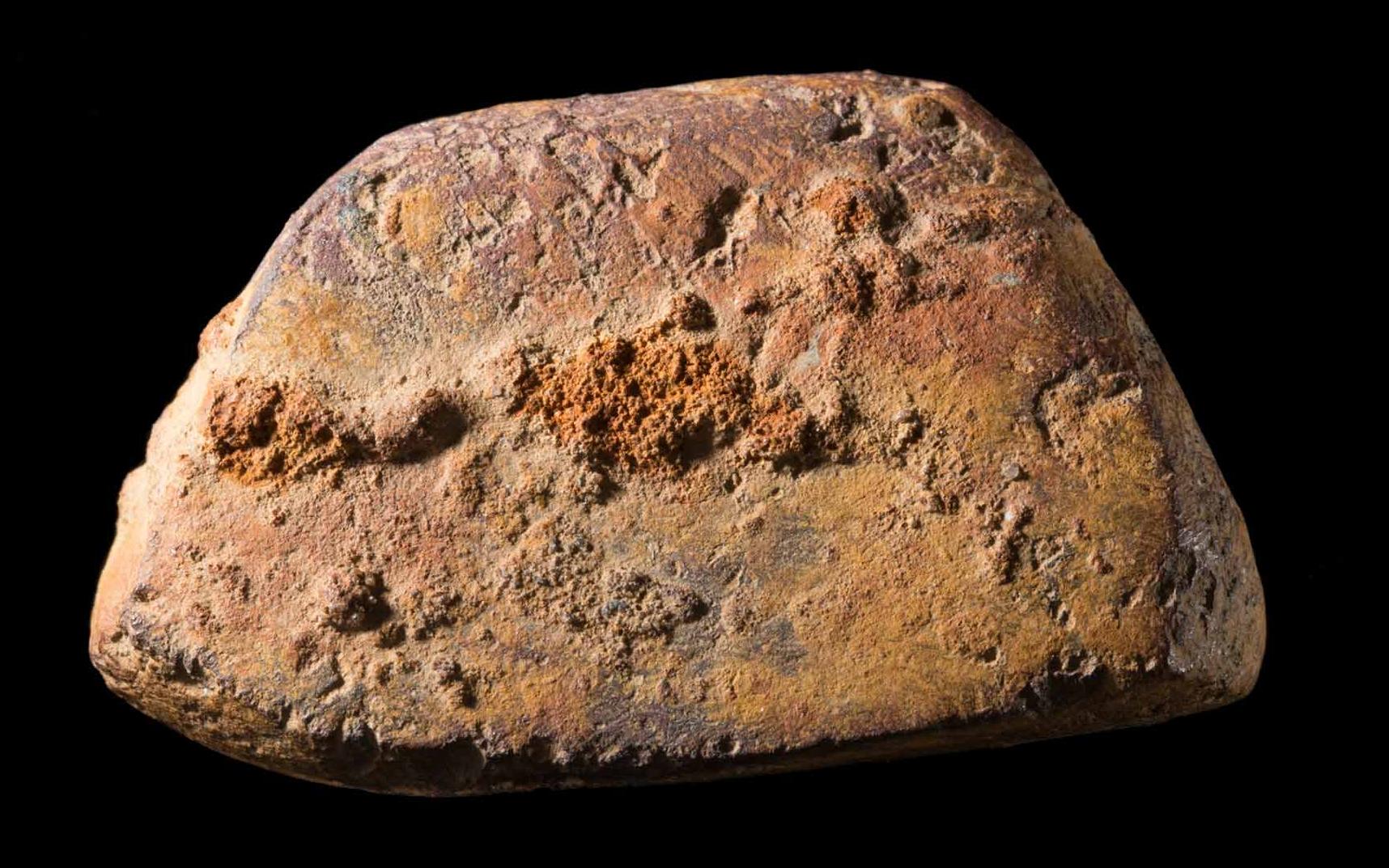 Photograph of a piece of ochre on a black background.